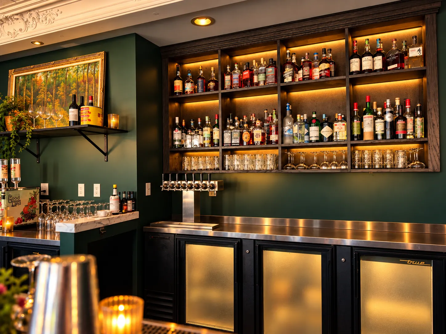 The backbar: lit shelves of bottles against deep green walls